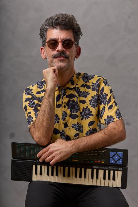 Retrato con camisa amarilla y un teclado Yamaha PortaSound