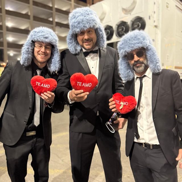 Tres integrantes de Tanghetto con gorros de peluche celestes y corazones rojos